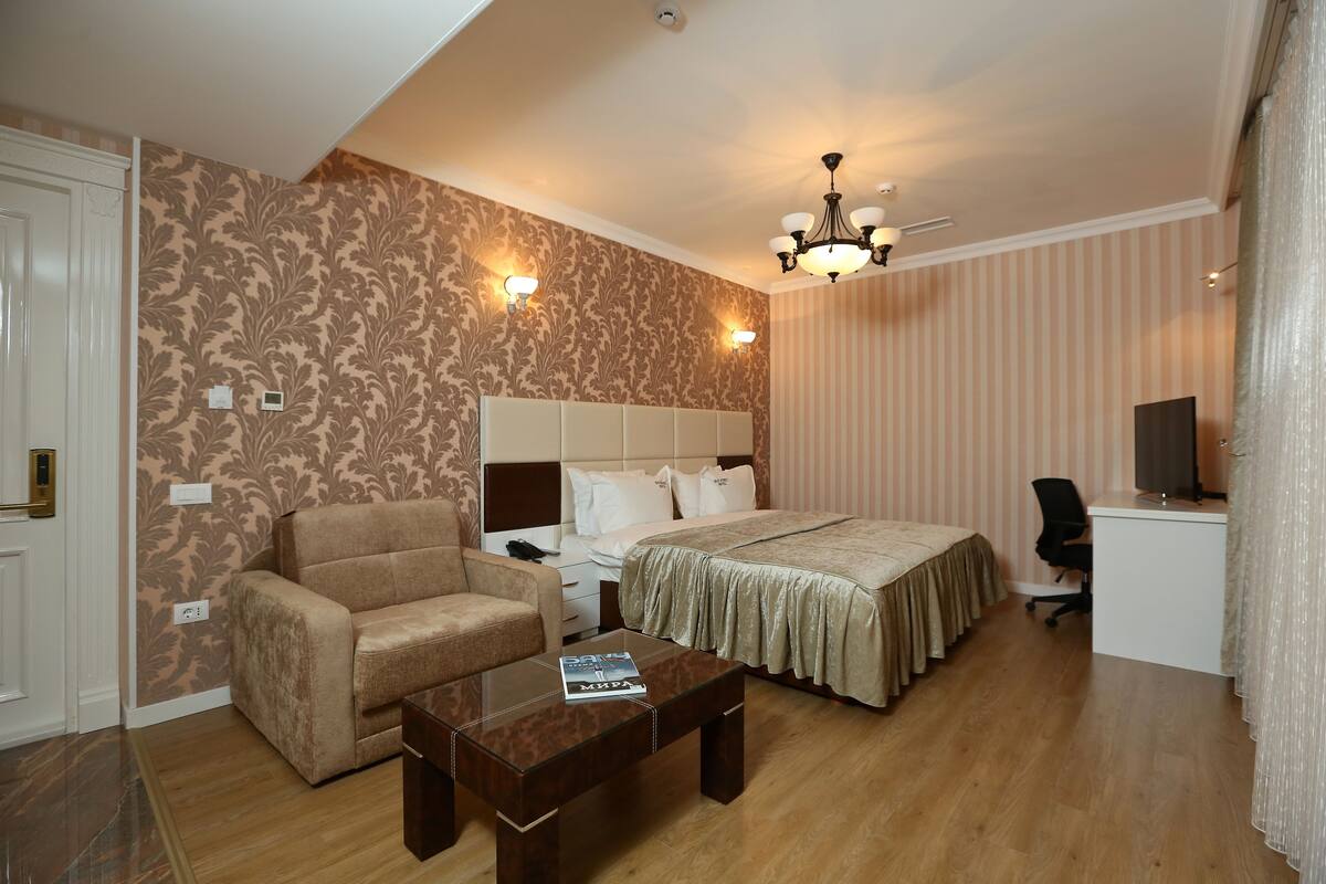 Een hotelkamer met een bed, een bank, een bureau en een salontafel.