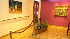 Una escalera con barandilla, una barrera de cuerda roja y plantas en macetas.