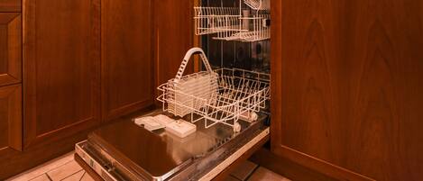 A kitchen with wooden cabinets, a dishwasher, and a stainless steel countertop.