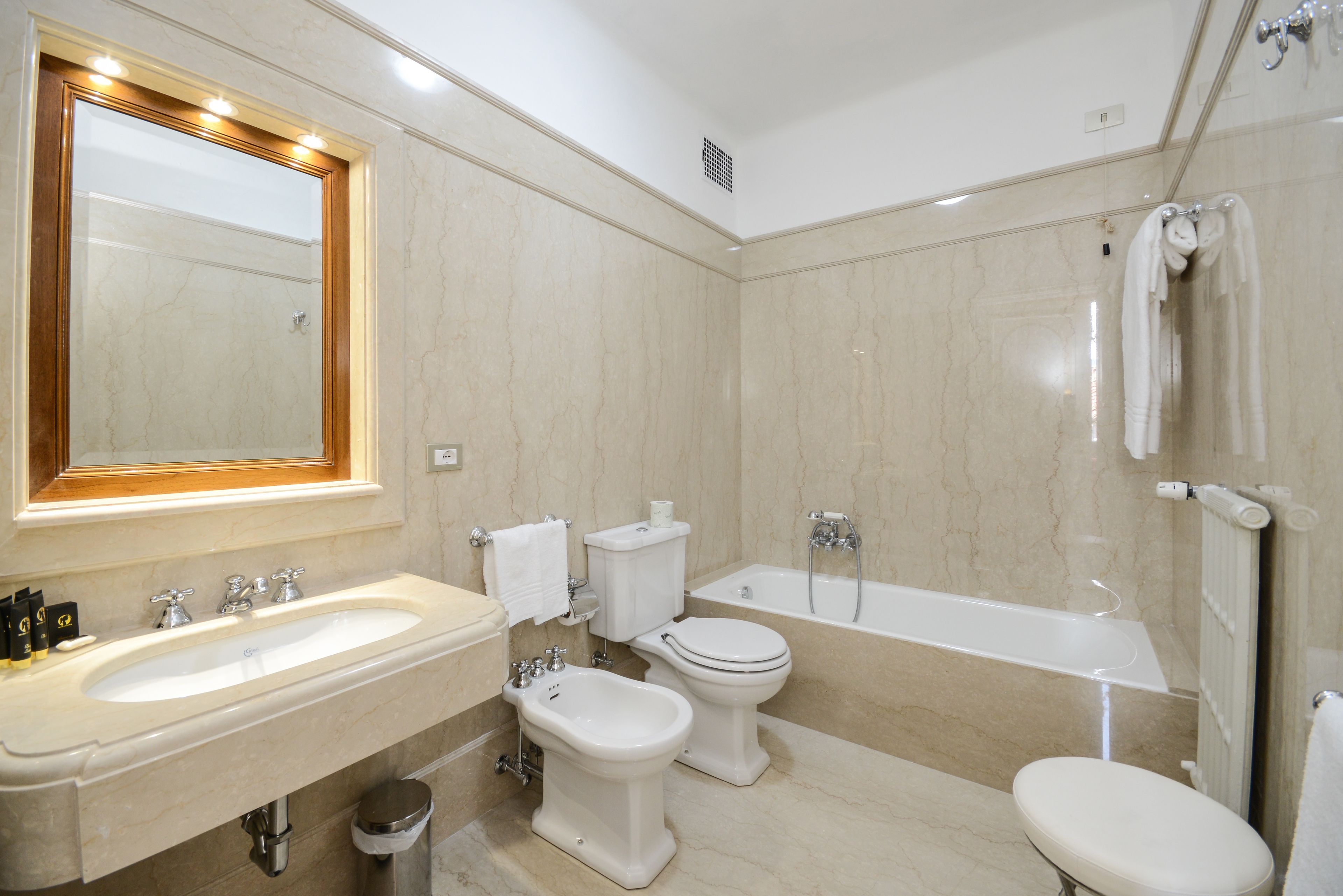 Un baño moderno con lavamanos, bidé, inodoro y bañera.
