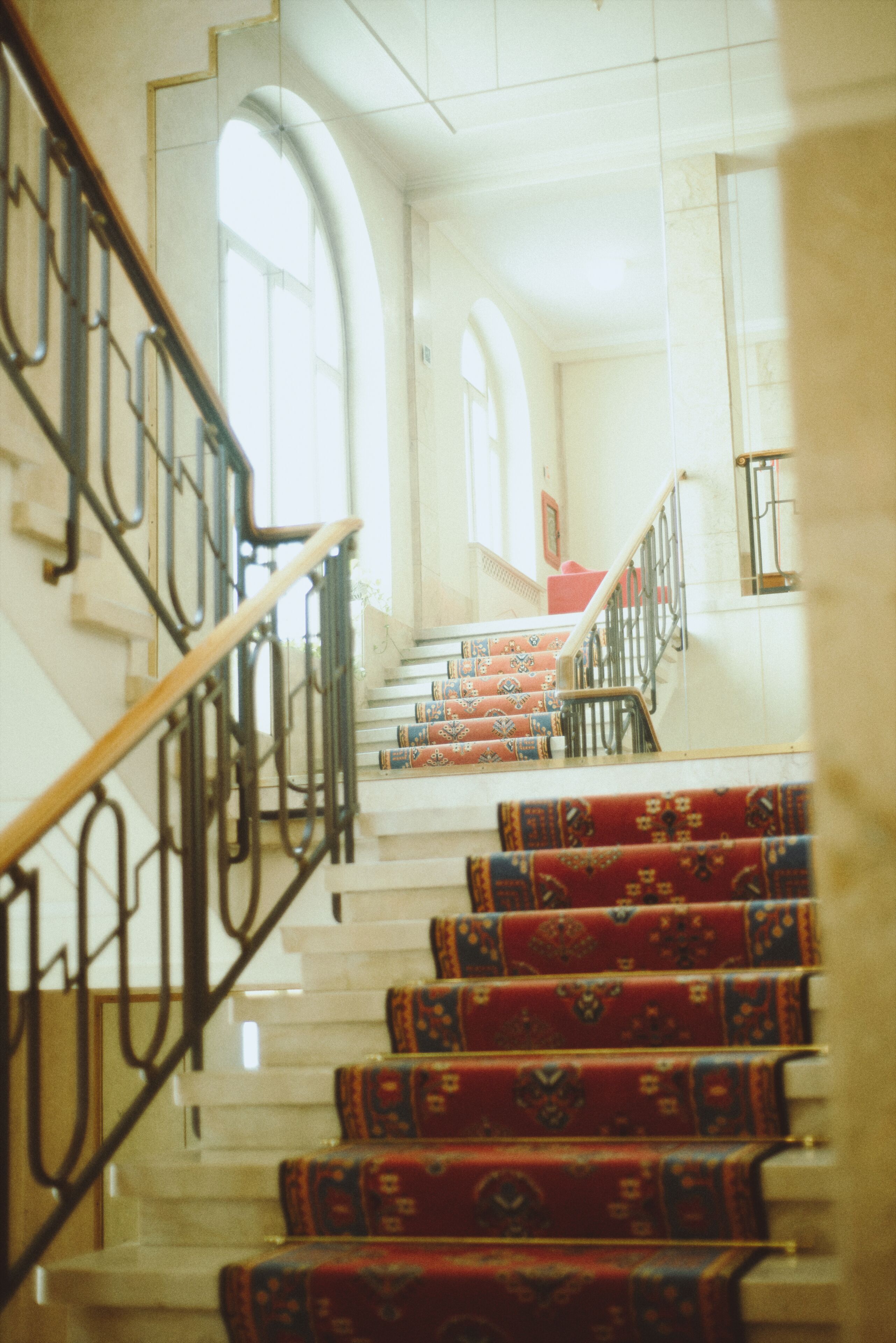 A staircase with ornate railings and patterned carpet.