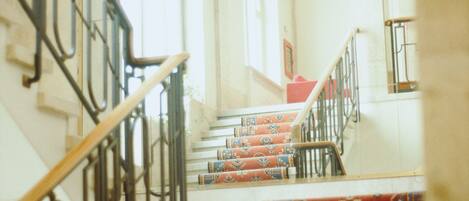 A staircase with ornate railings and patterned carpet.