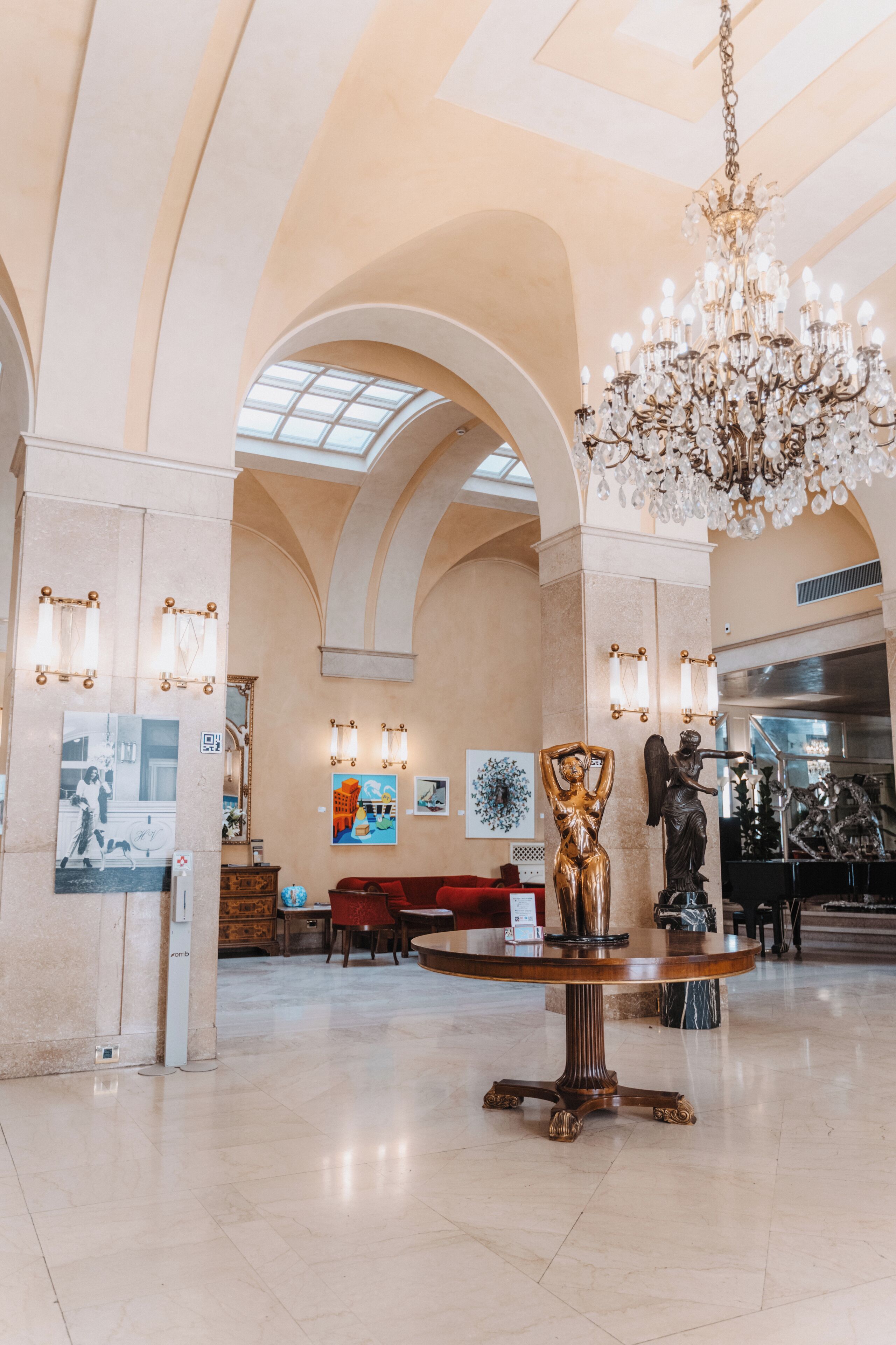 Un hall d’entrée spacieux, agrémenté d’un magnifique lustre, de plafonds en arc de cercle et d’œuvres d’art aux murs.