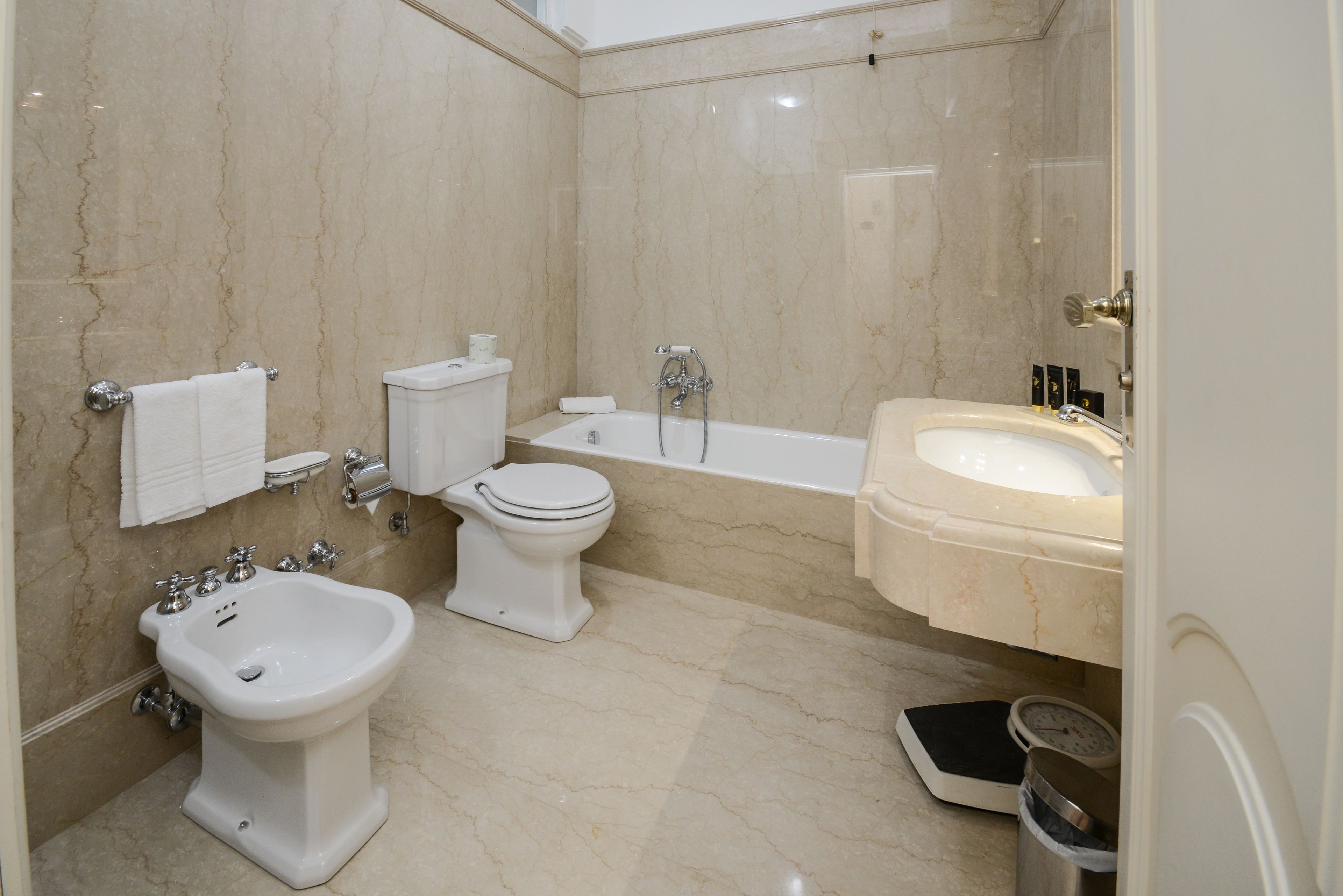 A bathroom with a bidet, toilet, bathtub, and sink.