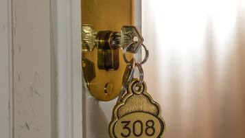 Eine Messing-Türgriff mit Schlüsselloch und ein Schlüsselbund mit der Nummer ‚308‘.