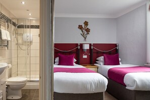 A hotel room with a shower, toilet, and two beds with pink and white bedding. - Springfield House - Birmingham Airport & NEC (Birmingham)