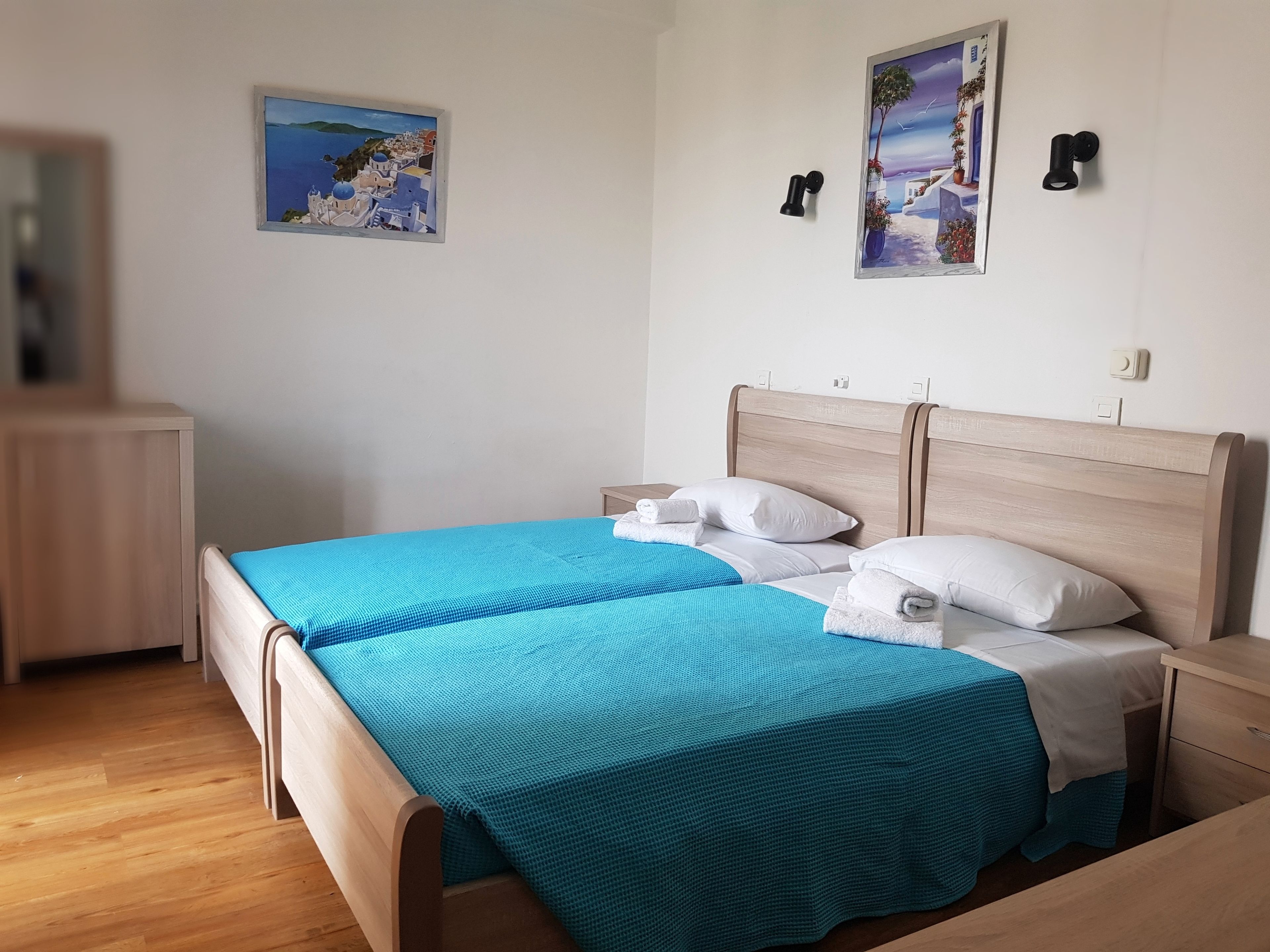 Ein ordentlich eingerichtetes Schlafzimmer mit einem Bett, Nachttischen und zwei Wandlampen.