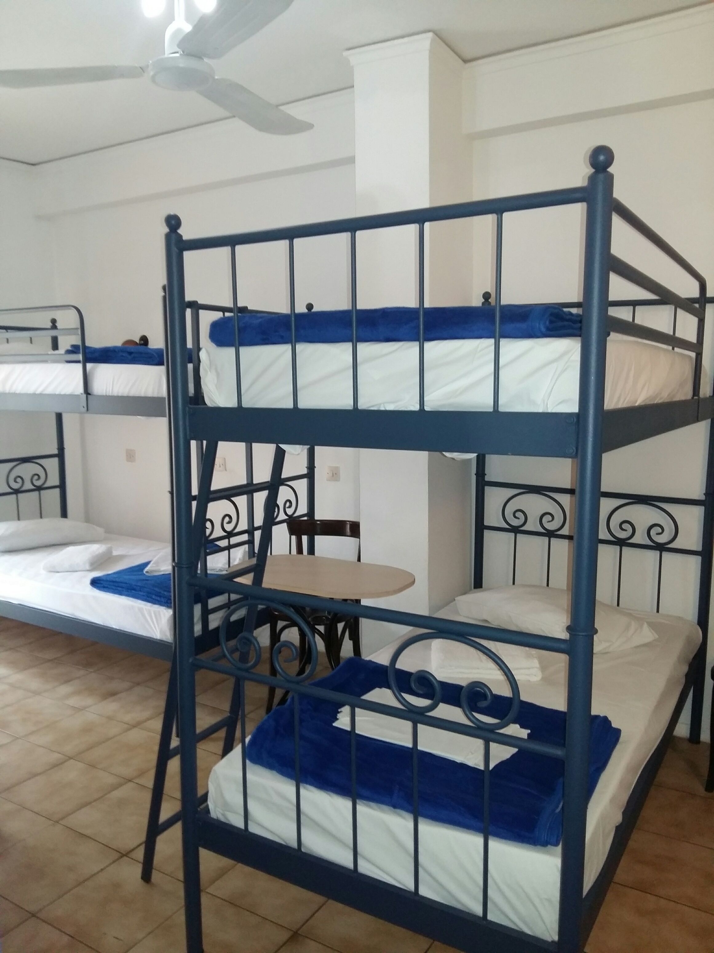 Habitación con literas, una mesa y sillas.