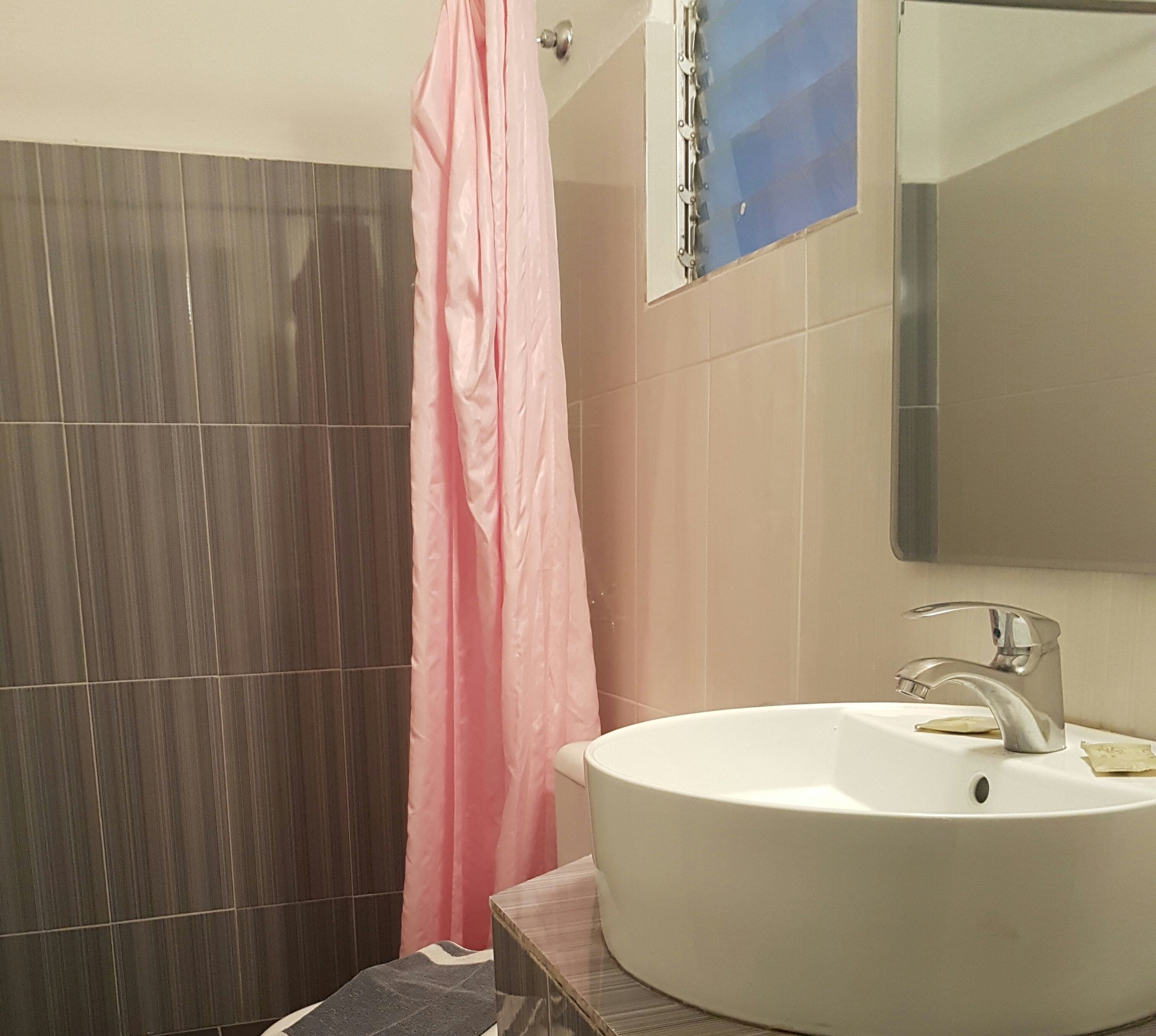 A bathroom with a white sink, a mirror, and a shower curtain.