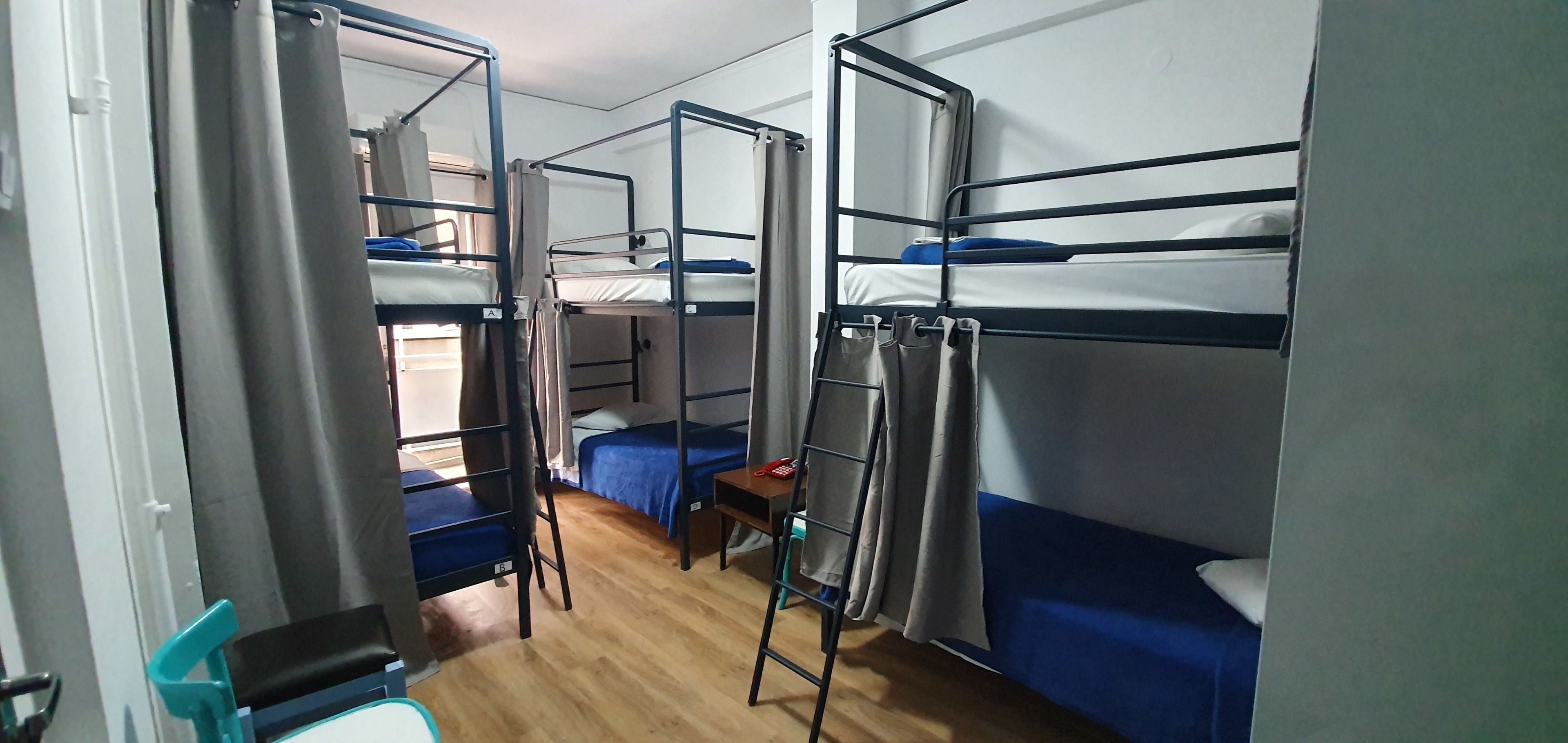 Un dormitorio con literas, una mesita pequeña y una silla.