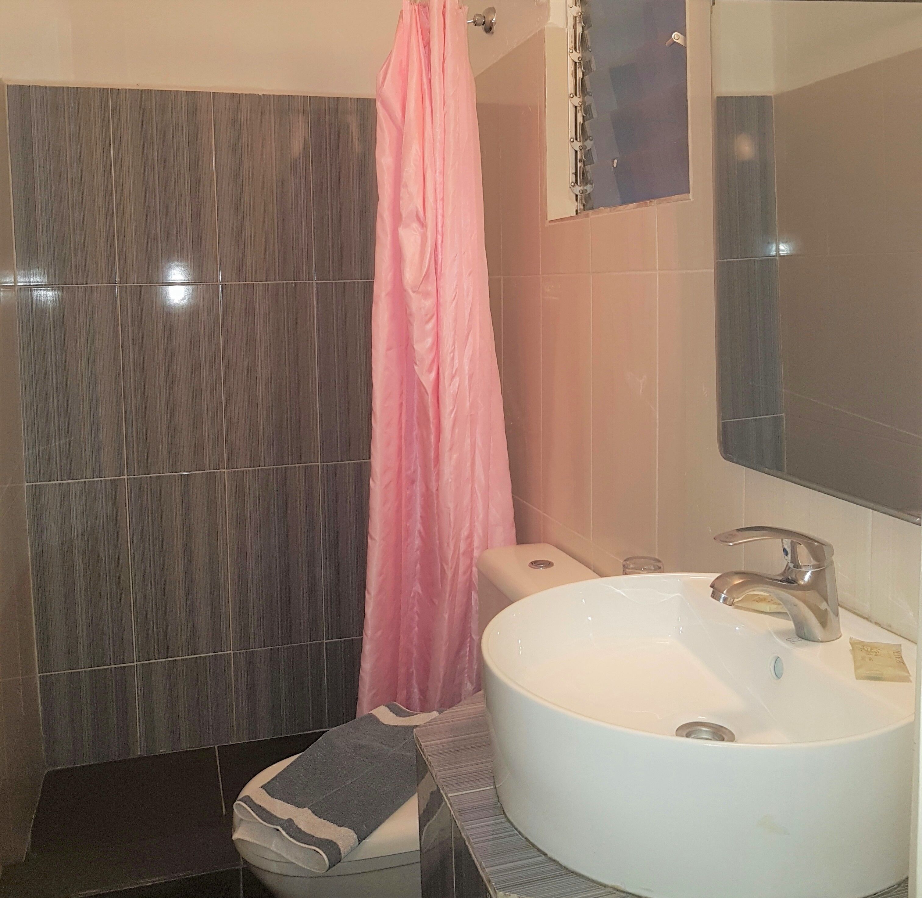 A bathroom with a white sink, a mirror, and a shower curtain.