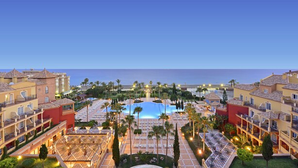 Ein Resort mit zentralem Pool, mehreren Balkonen und Meerblick.
