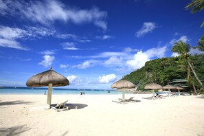 På stranden, solsenger, parasoller og strandhåndklær