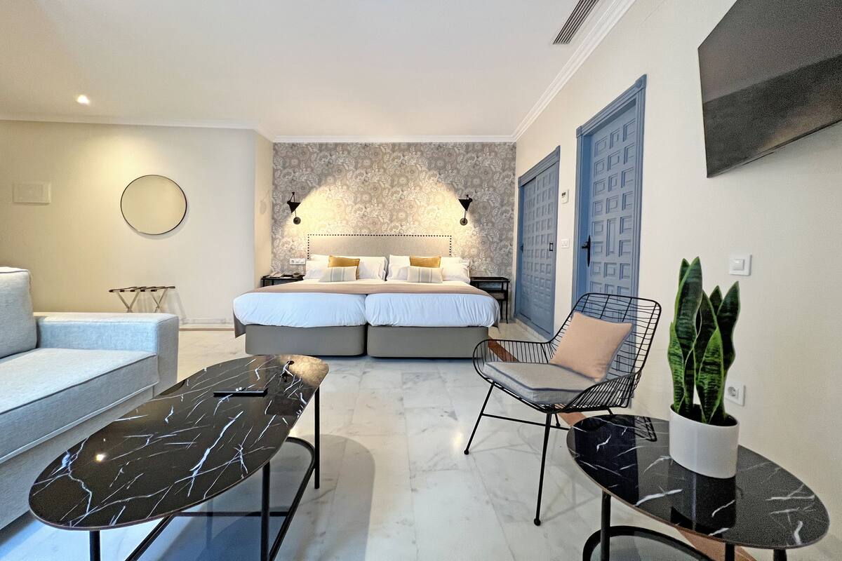 Une chambre moderne avec un grand lit, un canapé, une table à manger et une chaise.