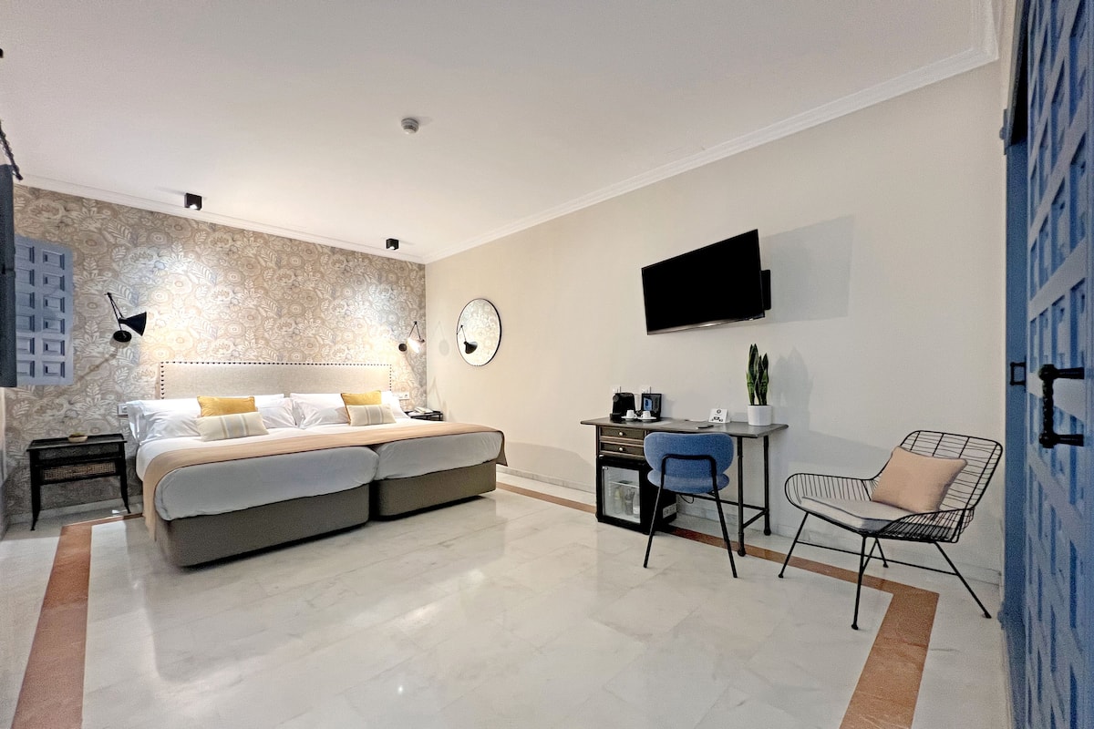 Une chambre moderne avec un lit, un bureau et un coin salon.