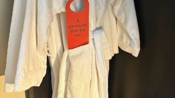 A white robe hanging on a wooden hanger with a tag that reads "A moment just for me."