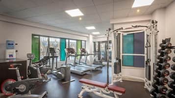 A gym with treadmills, a bench press, and a squat rack.