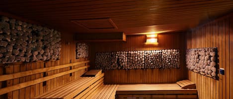 A sauna with wooden benches and walls lined with logs.
