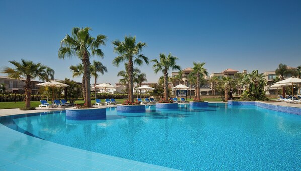 Una piscina al aire libre, sillones reclinables de piscina