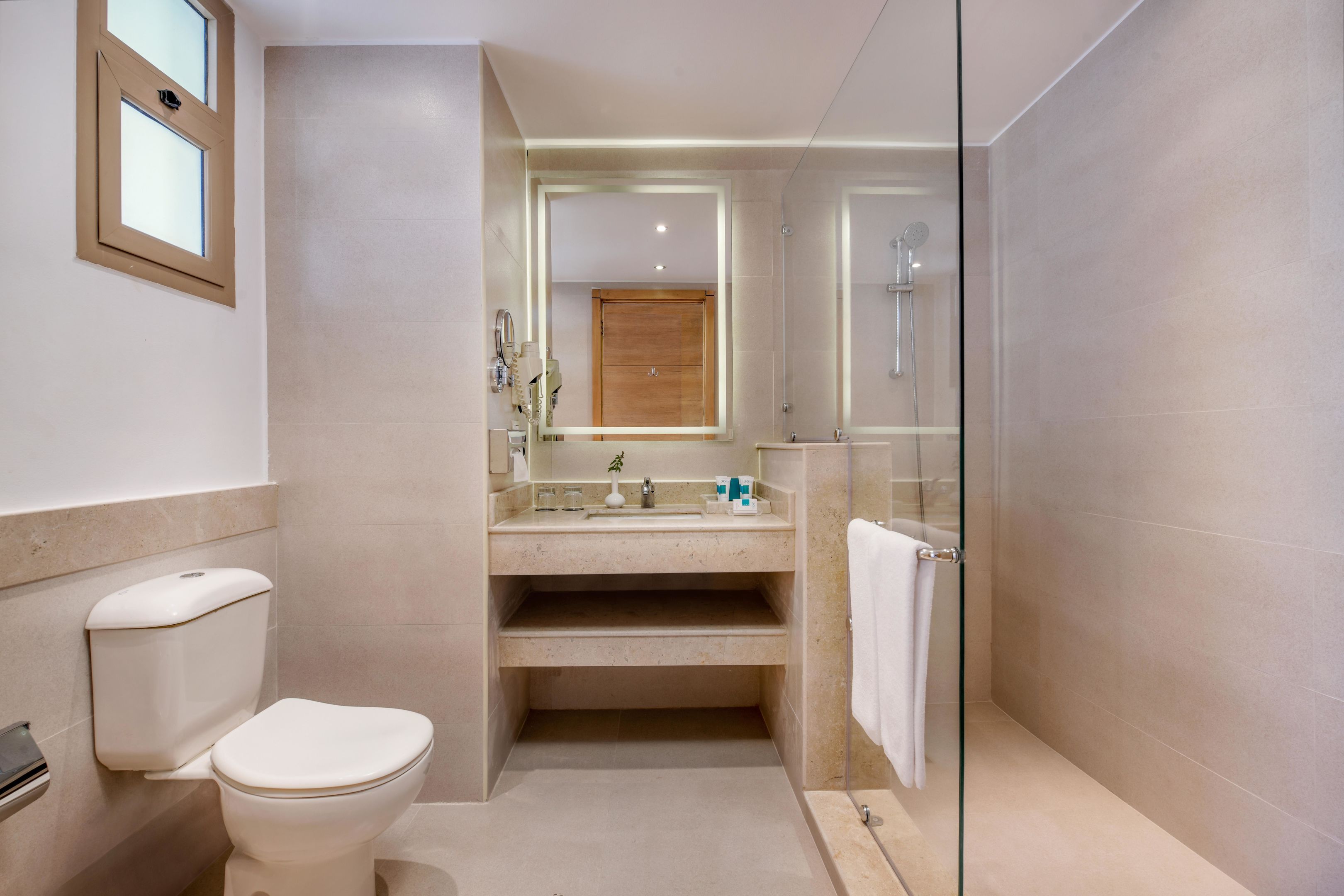 A modern bathroom with a toilet, sink, and shower.