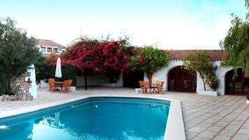 Een buitenzwembad, parasols voor strand/zwembad