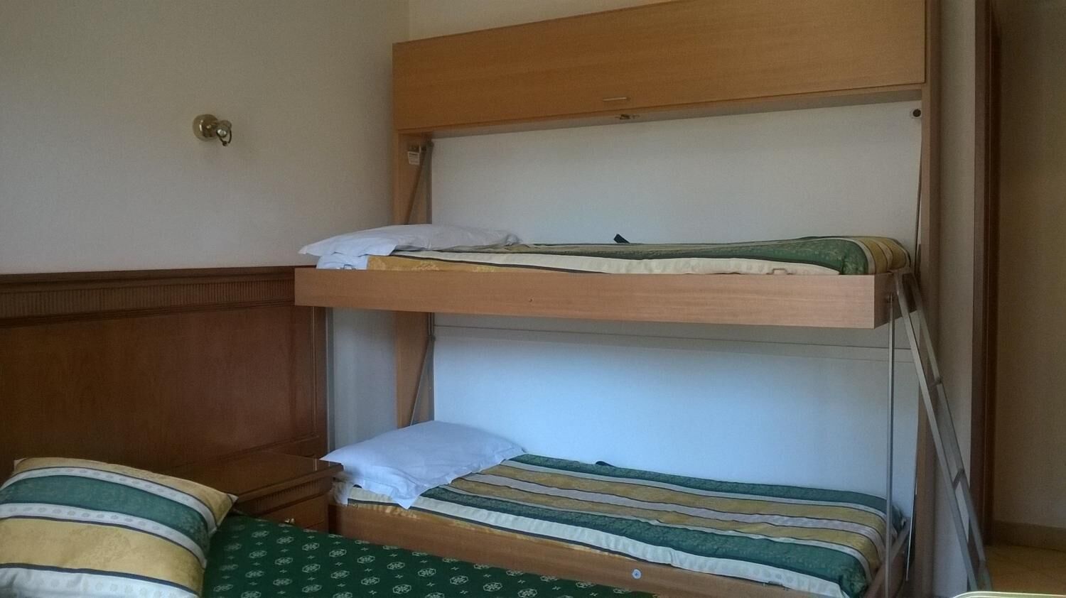 A bunk bed with two levels, each with a pillow and a blanket.