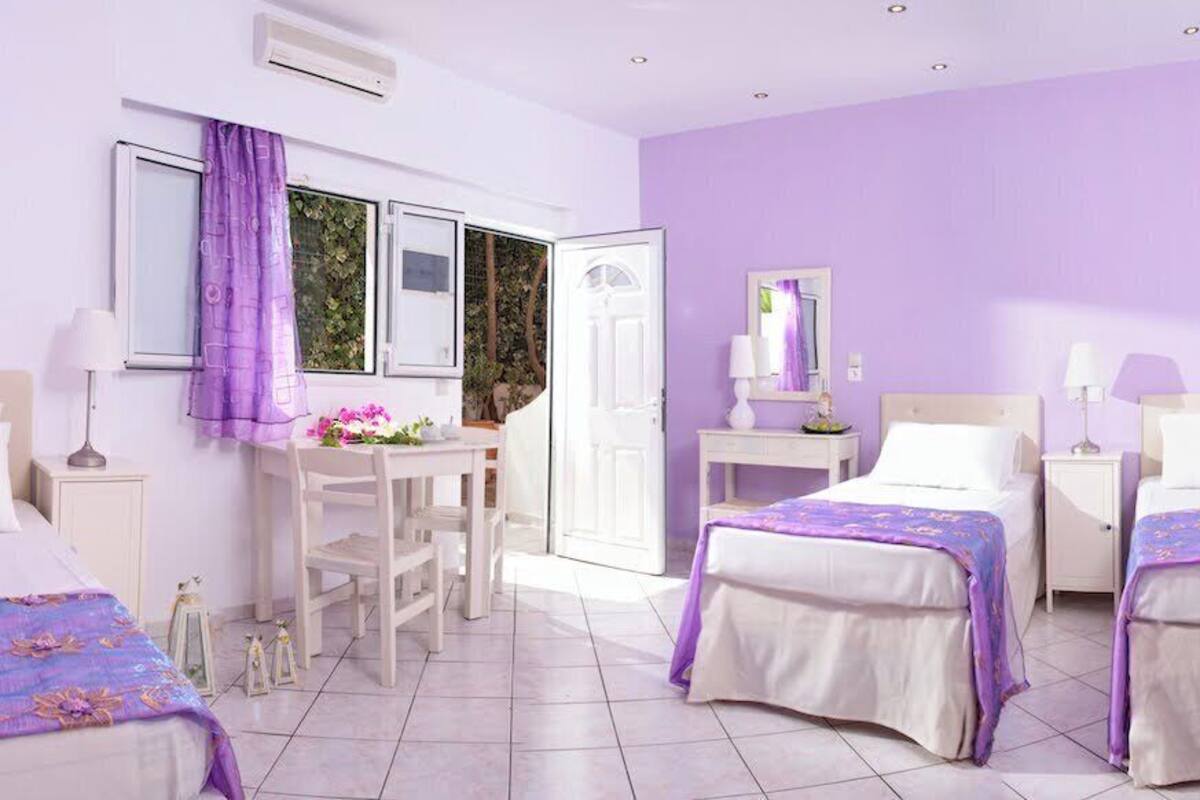 A hotel room with two beds, a desk, and a chair.