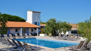 Relax by the rectangular pool surrounded by lounge chairs and lush greenery.