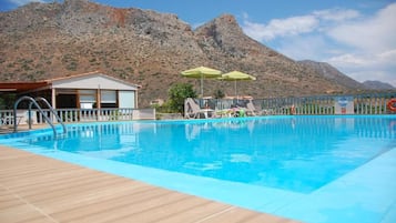 Piscine extérieure, parasols de plage, chaises longues