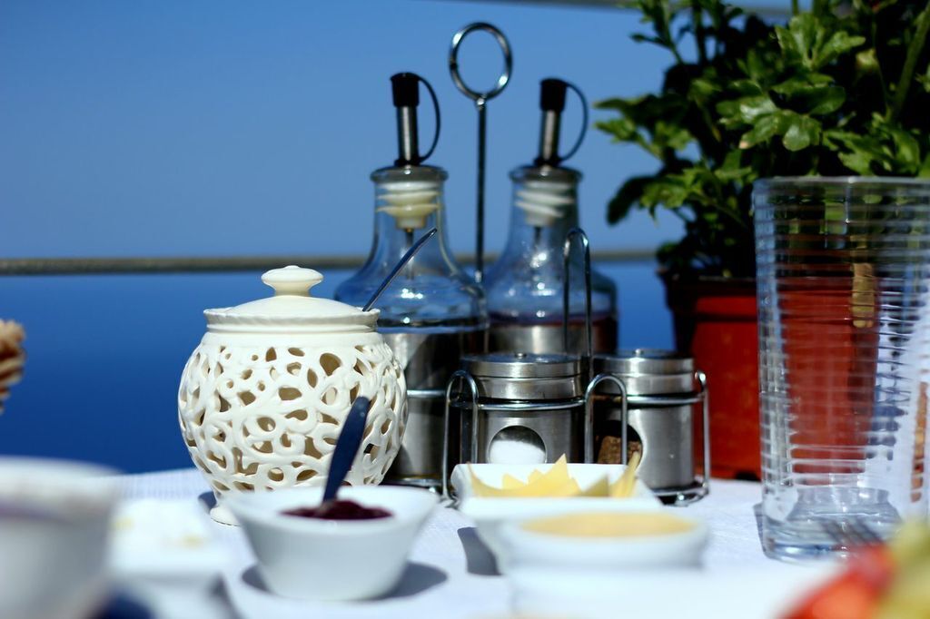 A table with various condiments and a decorative lantern, set against a blue background.