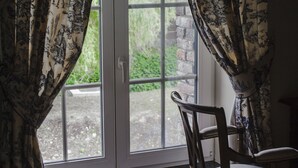 A room with a window, curtains, and a chair. - Kamerijck Bed & Breakfast (Gingelom)