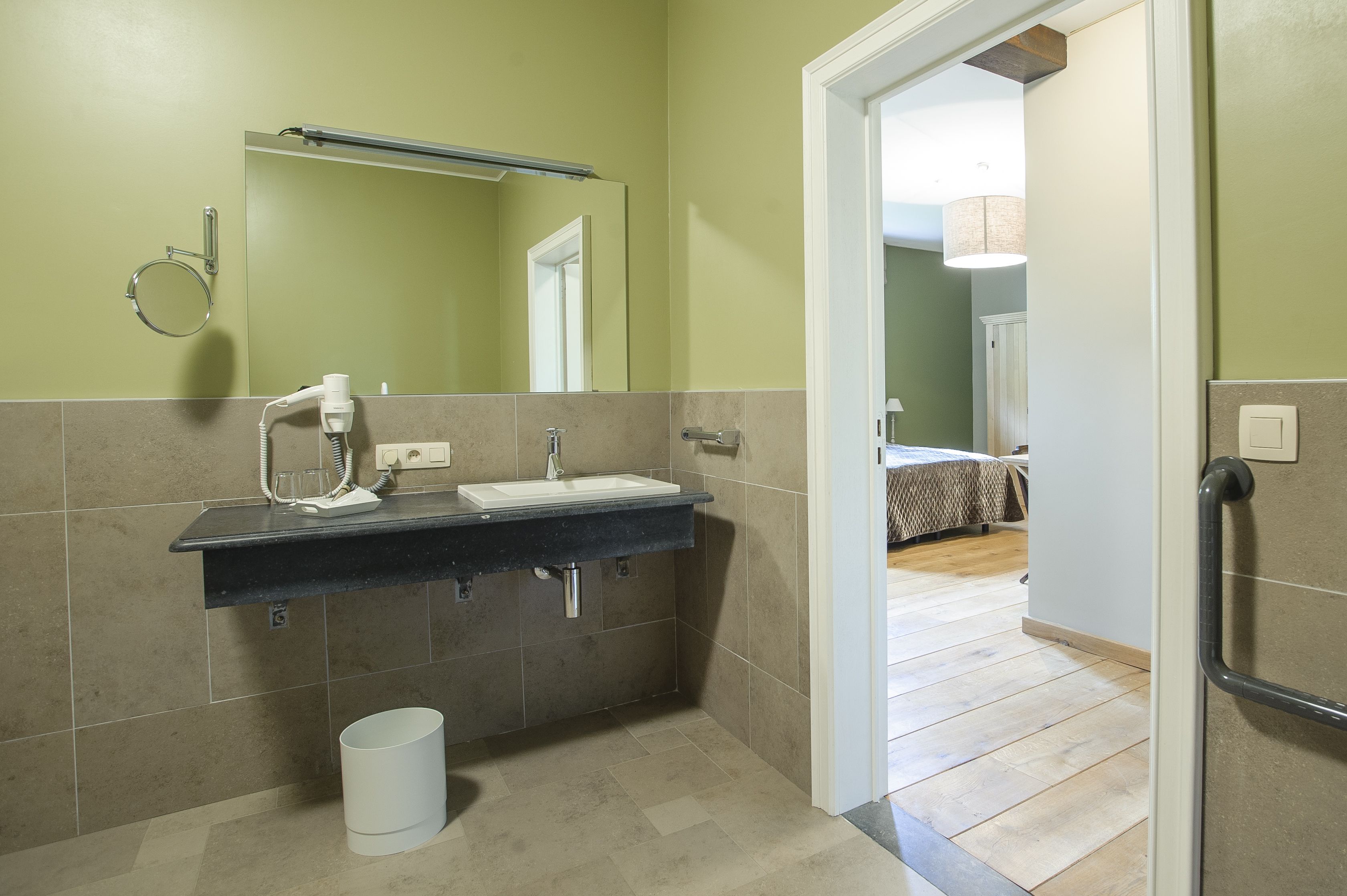 A bathroom with a sink, mirror, and towel rack.