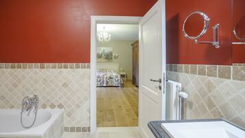 A bathroom with a bathtub, a sink, and a mirror.