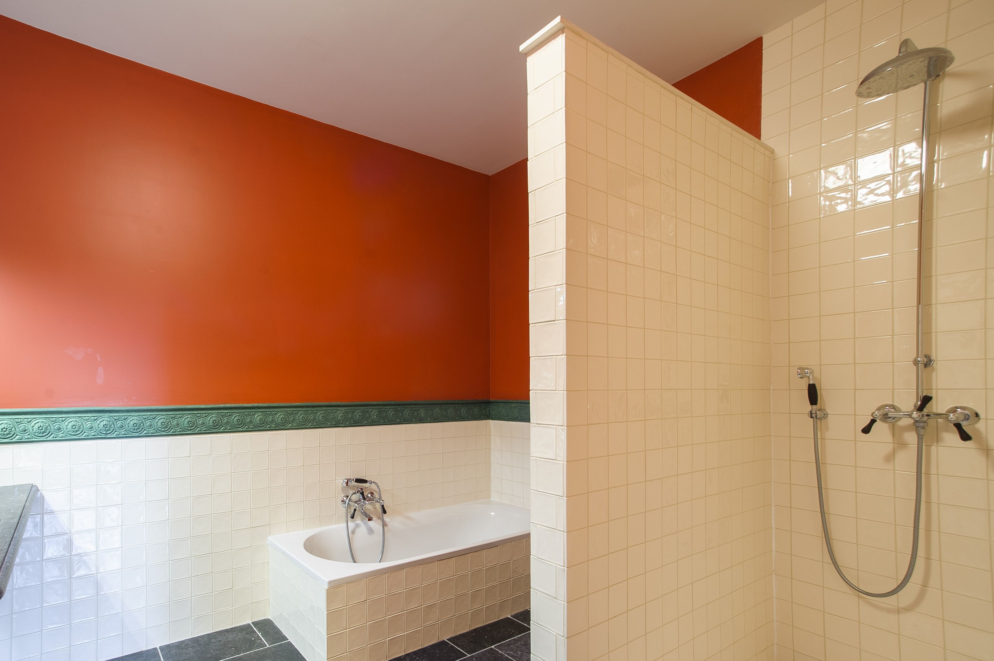 A bathroom with a bathtub, a shower, and tiled walls.