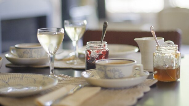 A dining table set with plates, glasses, and jars of jam. - Kamerijck Bed & Breakfast (Gingelom)