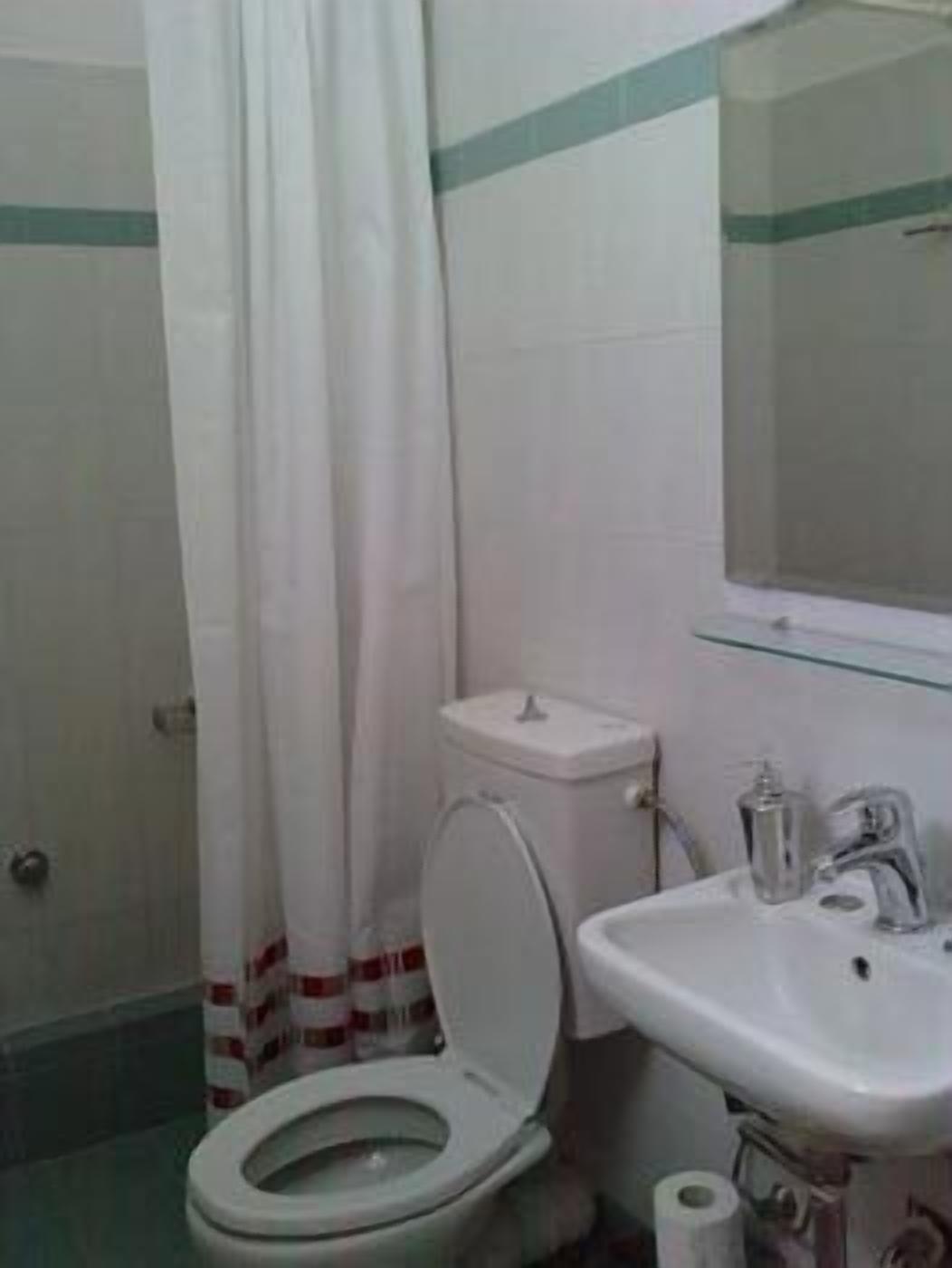 Une salle de bain avec des toilettes, un lavabo et un miroir.