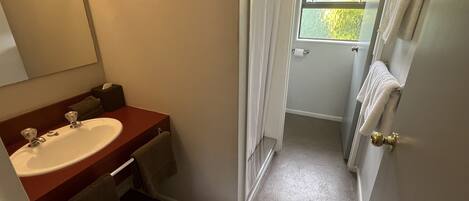 A bathroom with a sink, mirror, and towel rack.