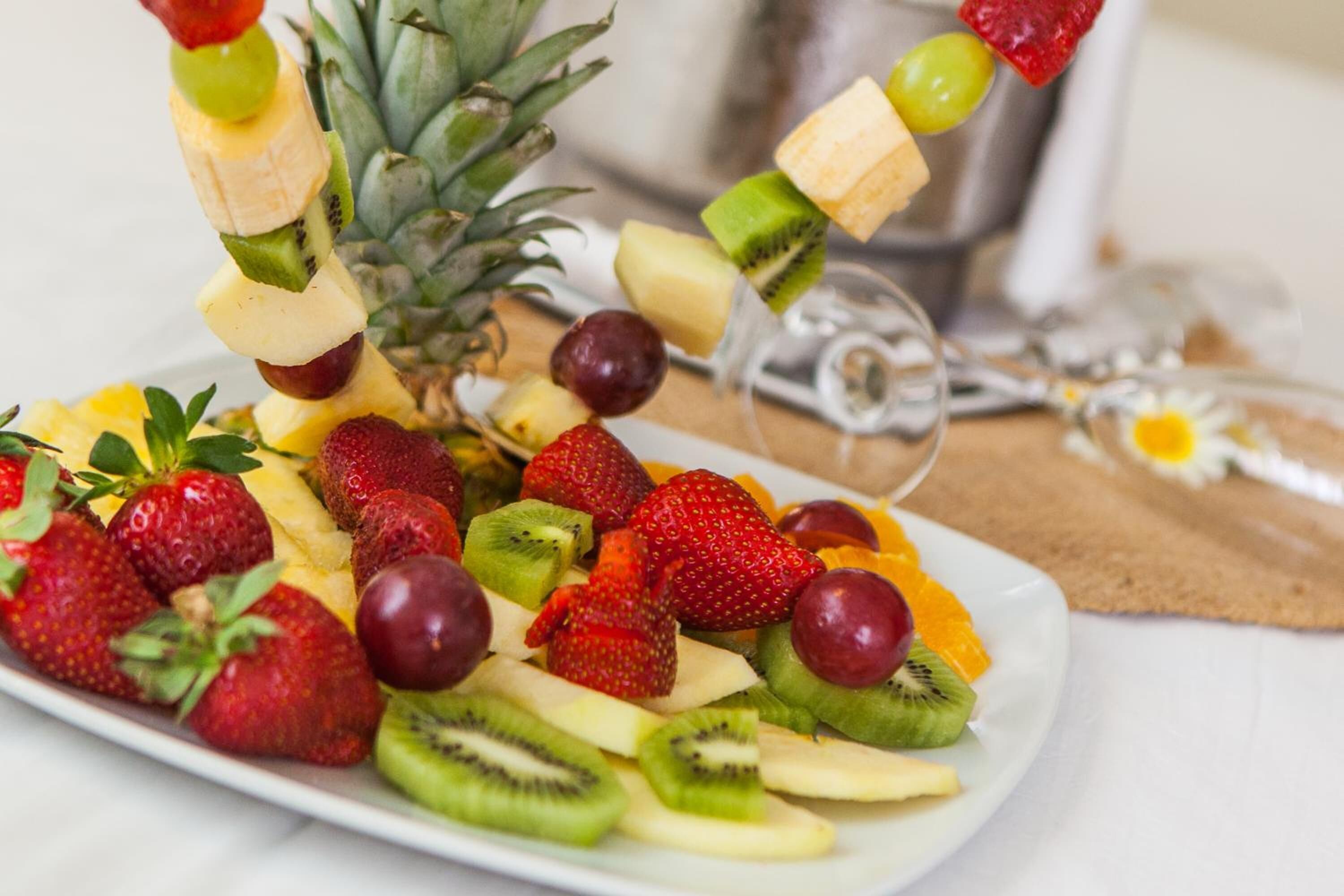 A fruit platter with various fruits including strawberries, kiwi, grapes, and pineapple.