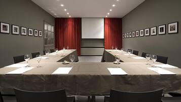 A conference room with a long table, chairs, and framed pictures on the walls.