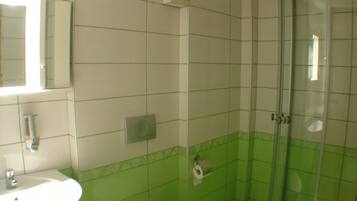 A bathroom with a sink, toilet, and shower.