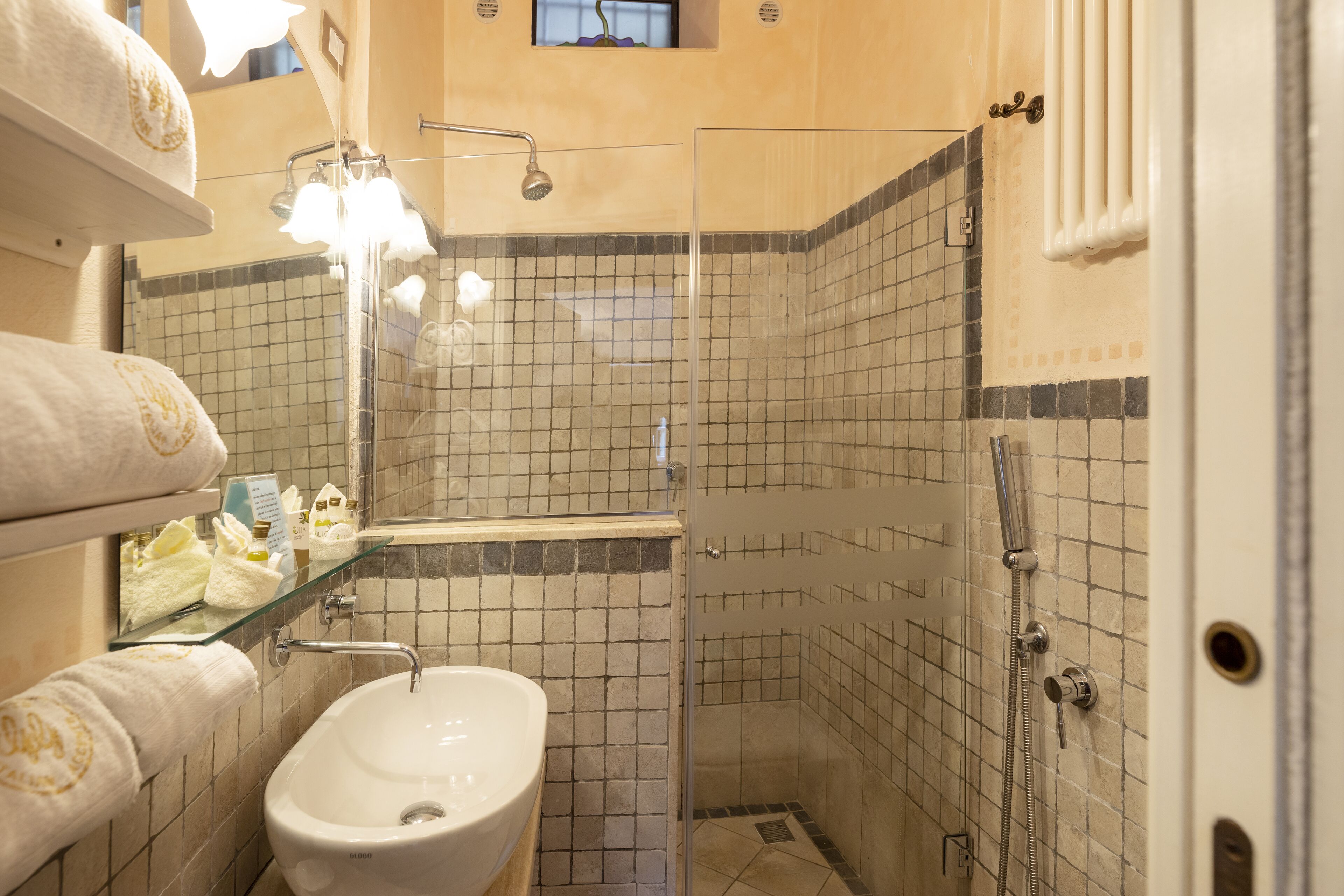 Une salle de bain avec une douche à parois de verre, un lavabo et un miroir.