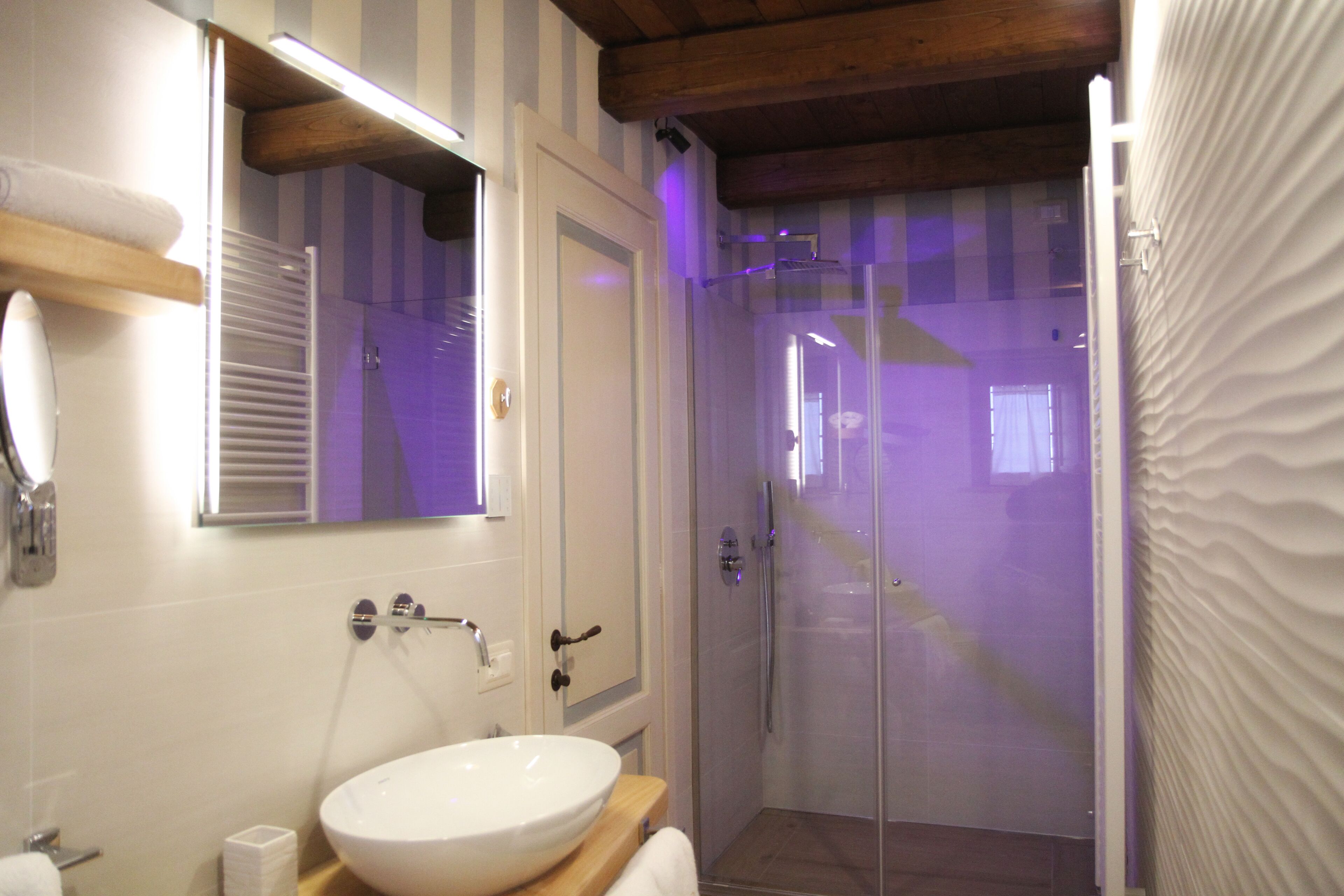 A bathroom with a white sink, mirror, and shower.