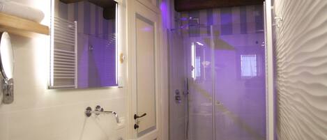 A bathroom with a white sink, mirror, and shower.
