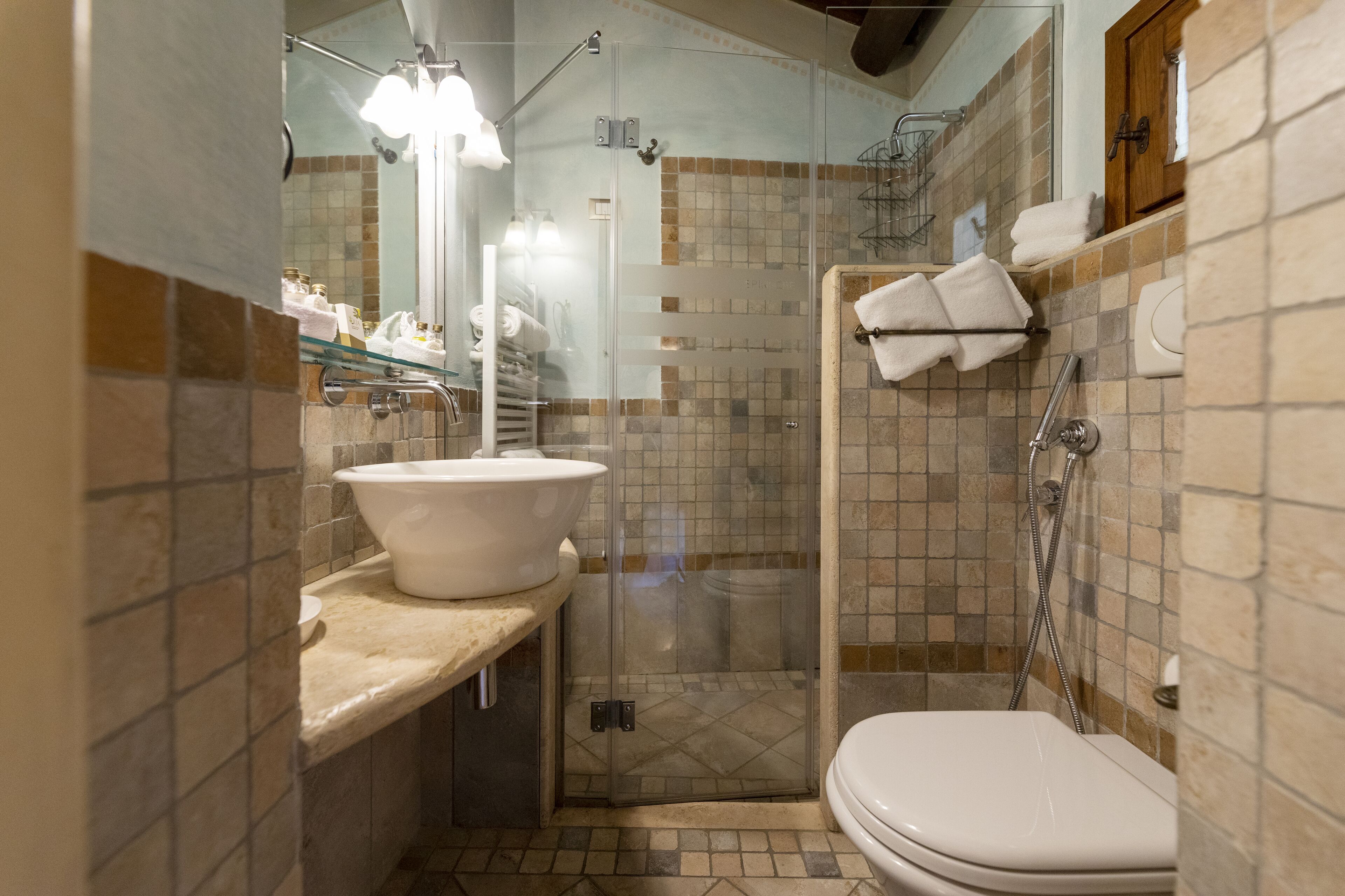 Ein Badezimmer mit einer gläsernen Dusche, einem Waschbecken mit großzügiger Spüle und einer Toilette.