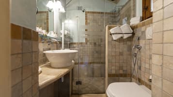 Ein Badezimmer mit einer gläsernen Dusche, einem Waschbecken mit großzügiger Spüle und einer Toilette.
