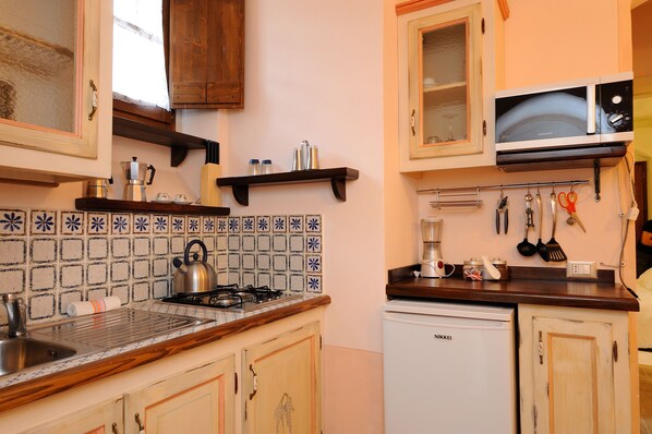 Una cocina con estufa a gas, microondas y lavavajillas.