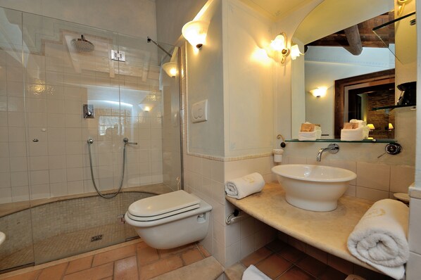 Un baño con ducha de vidrio, inodoro, lavamanos y espejo.