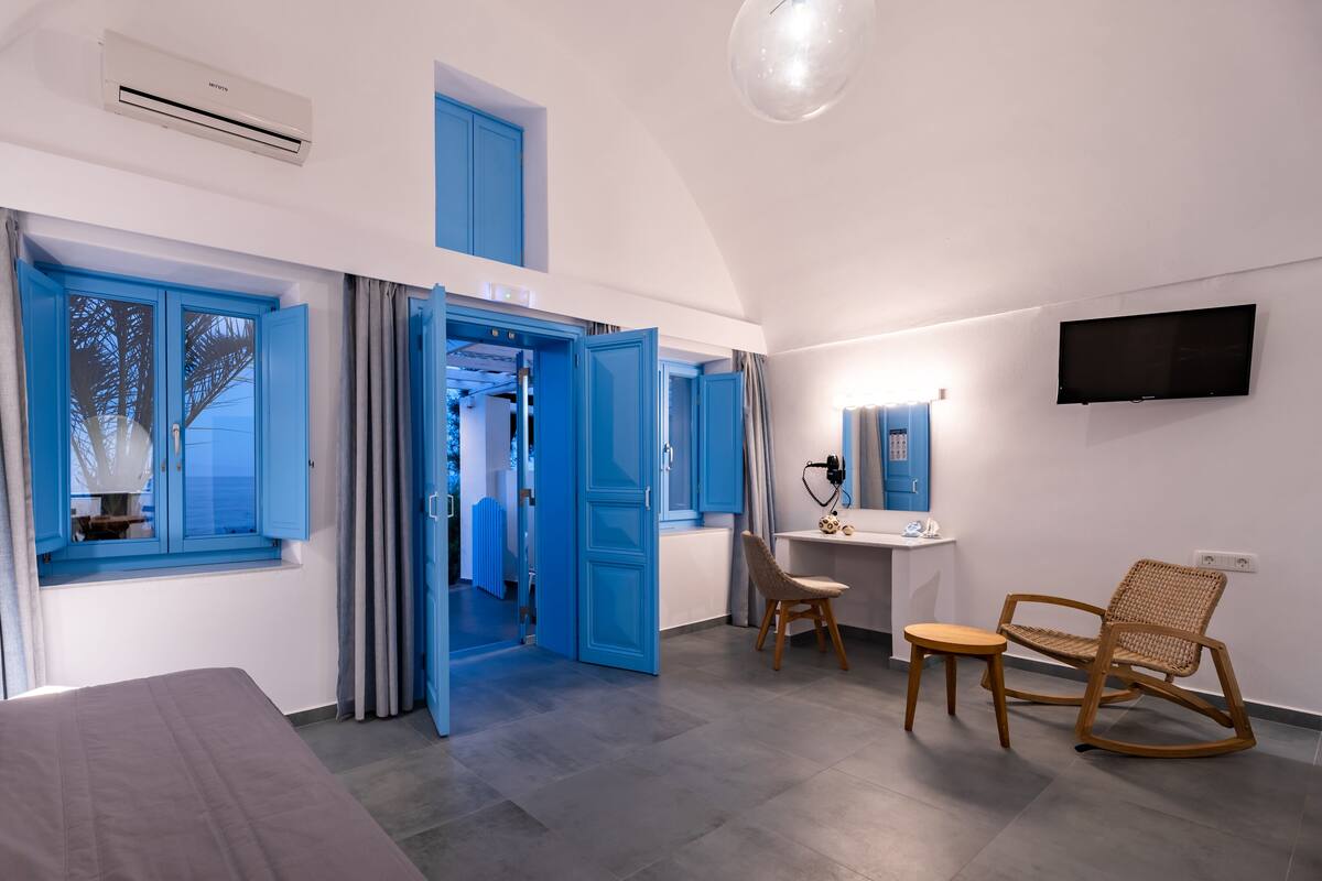Une chambre à coucher moderne avec un lit, un bureau, une chaise et un téléviseur.