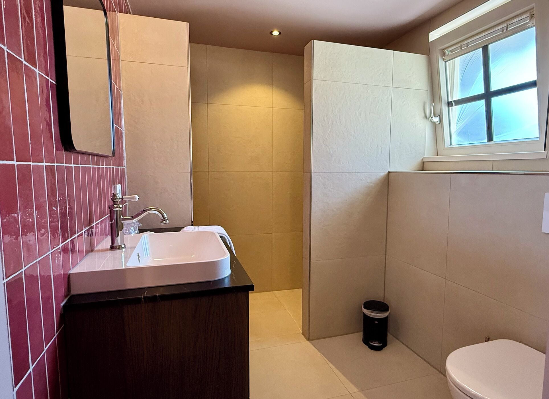 A bathroom with a sink, mirror, and toilet.
