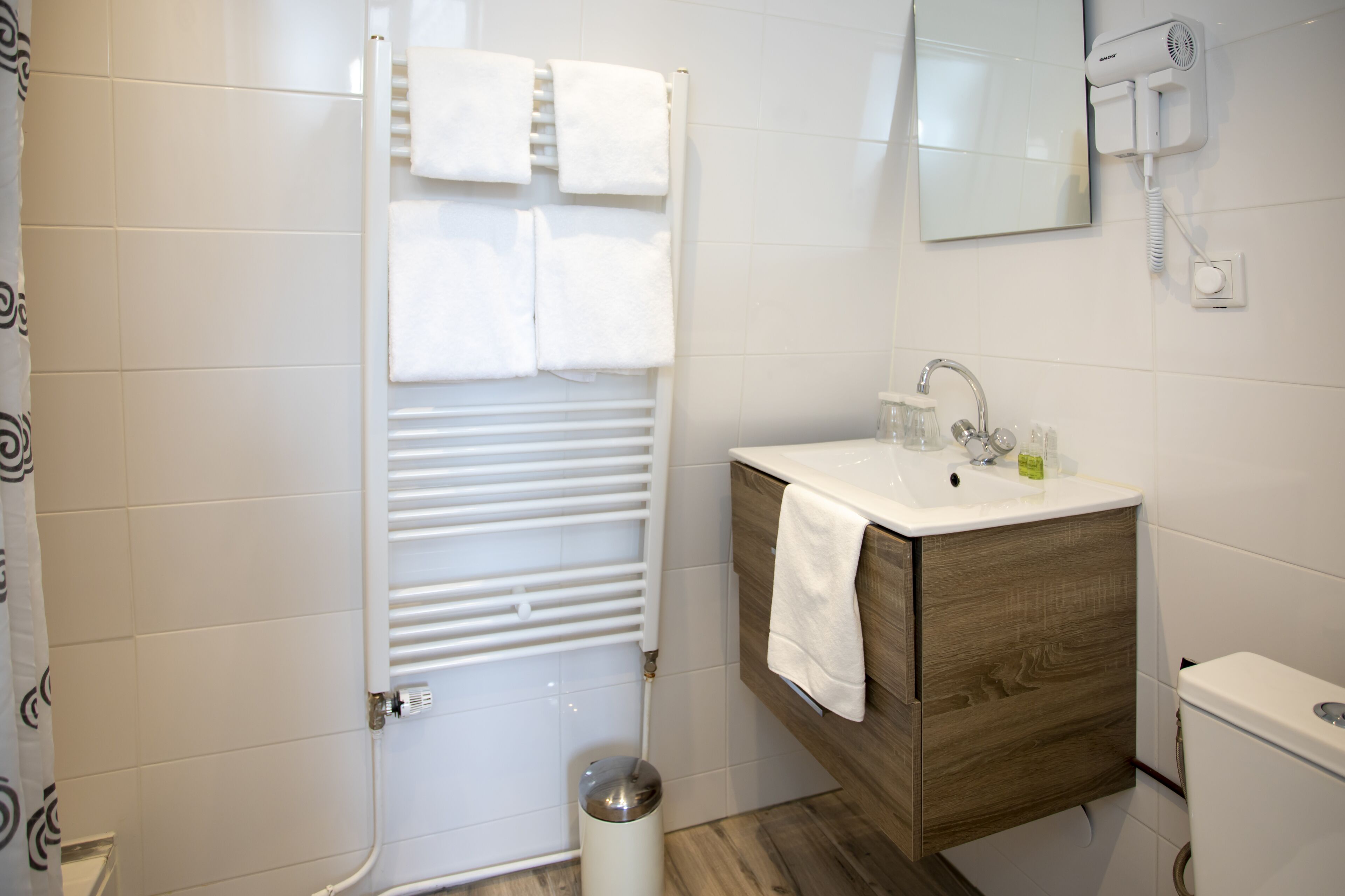 A modern bathroom with a shower, a sink, and a toilet.